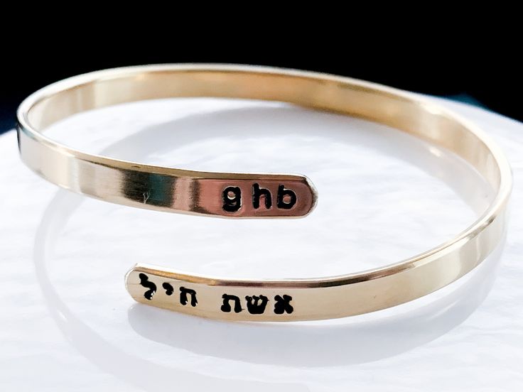 Celebrate your strength with this personalized wraparound bangle bracelet. Fashioned in brass, sterling silver, 14K gold filled, or 14K rose gold filled, this meaningful design showcases a trendy, sleek wraparound design. Complete this look with two names or phrases of your choice - each up to seven characters in length - inscribed in a tiny English and Hebrew font. FEATURES Adjustable - just slip on like a bangle bracelet and give a gentle squeeze 4.5-5mm wide Choose your wrist size and I will Personalized Adjustable Cuff Bracelet, Personalized Spiritual Bangle Bracelet, Personalized Cuff Bracelet As Gift, Mother's Day Bracelet Jewelry For Anniversary Gift, Mother's Day Gift Cuff Bracelet, Mother's Day Anniversary Gift Jewelry Bracelet, Adjustable Bangle Bracelets For Anniversary, Adjustable Engraved Bangle For Anniversary, Adjustable Bracelets For Anniversary Gift