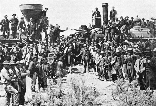 an old black and white photo of men standing in front of a train with tanks on it