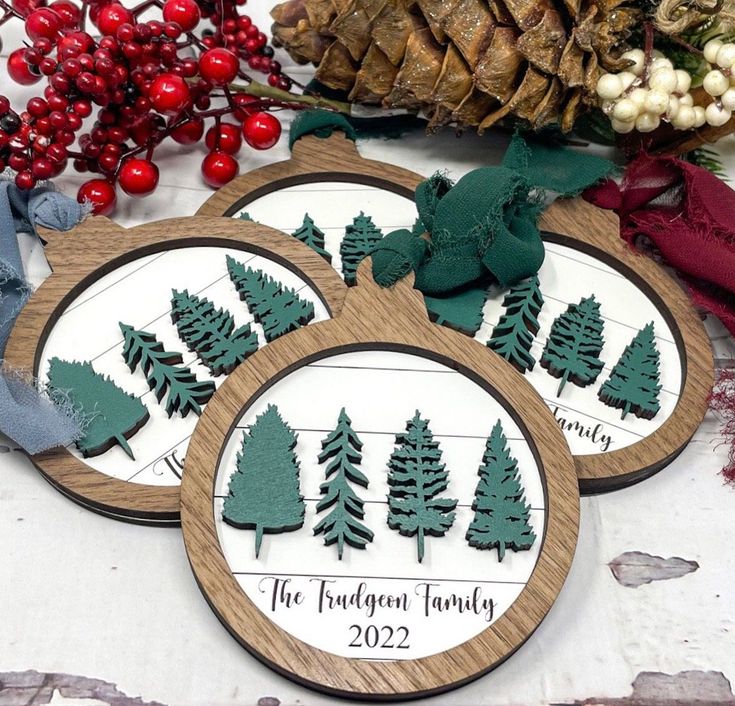 three wooden coasters sitting on top of a table next to christmas decorations and pine cones