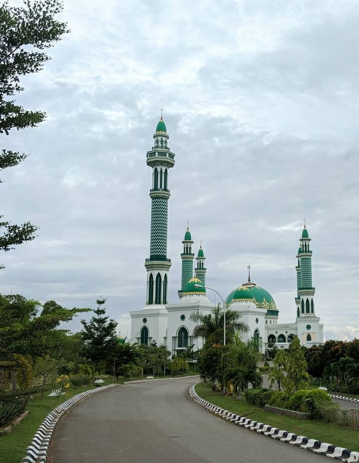 a large white building with green domes on it's sides and a road in front