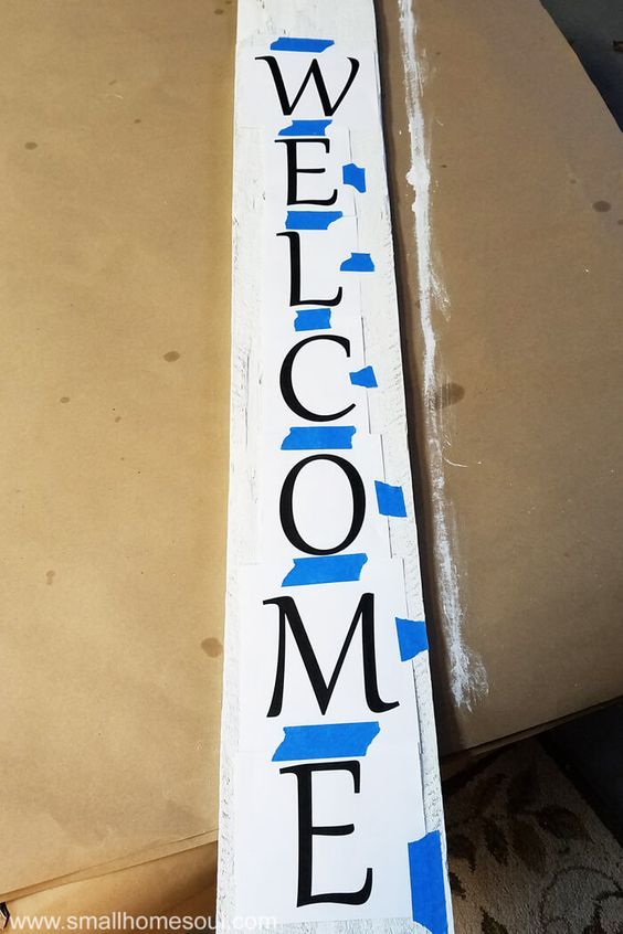 a wooden welcome sign sitting on top of a table