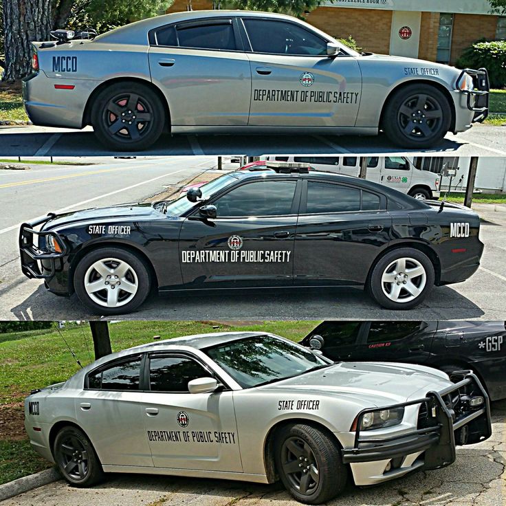 two police cars parked next to each other in front of a building and another car with the word department of public safety written on it