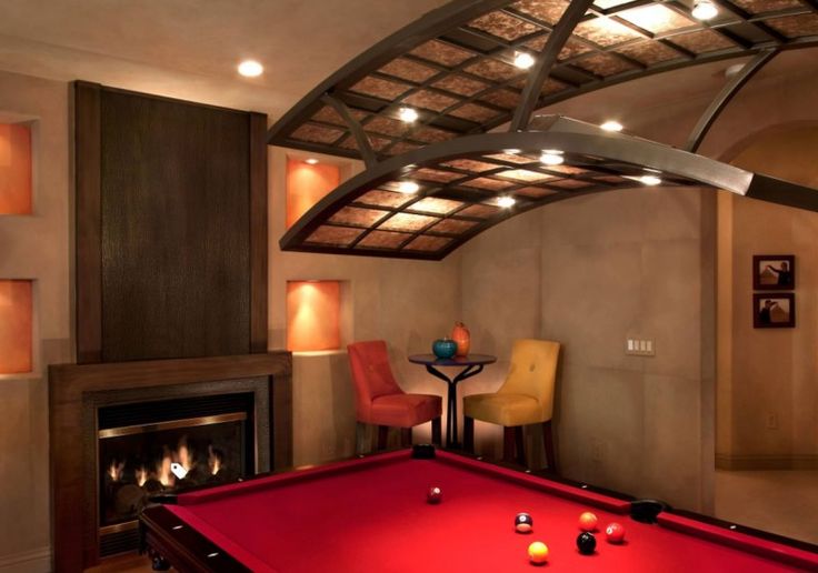 a red pool table sitting in front of a fire place