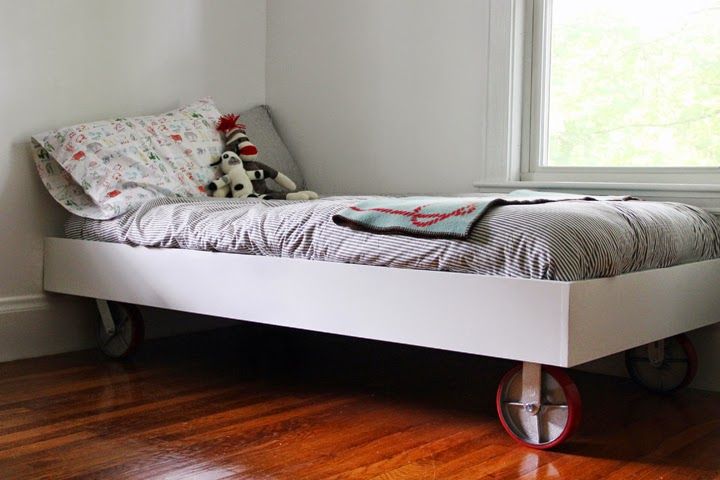 a white bed sitting on top of a hard wood floor