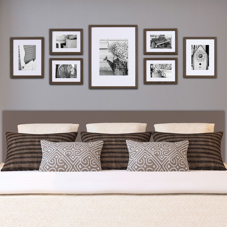 a bed with pillows and pictures on the wall