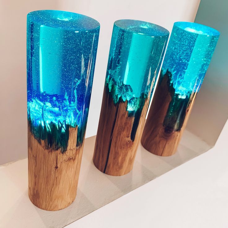 three blue vases sitting on top of a white counter next to each other in front of a mirror