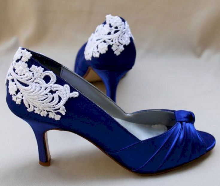 a pair of blue high heels with white appliques on the toes and heel