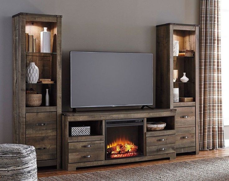 a living room with a fireplace and entertainment center in front of a flat screen tv