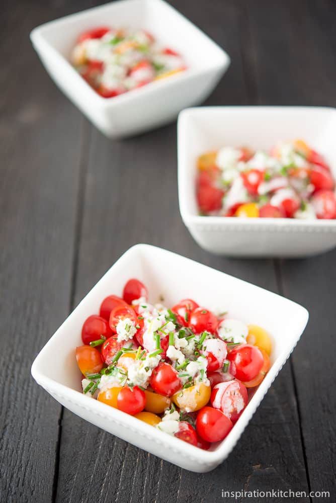 three small white bowls filled with different types of food on top of a wooden table