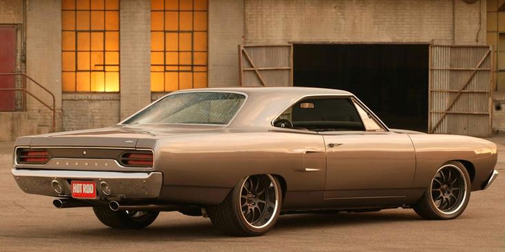 an old muscle car parked in front of a building