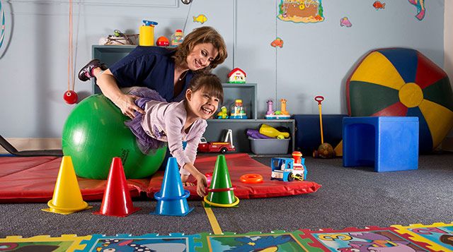 an adult and child playing in a play room