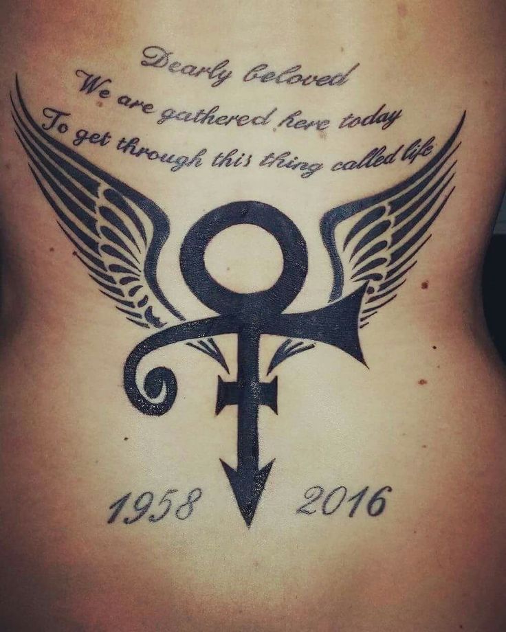 the back of a woman's stomach with an arrow and wings tattoo on it