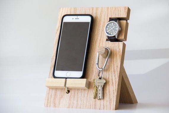 a cell phone, watch and keys on a wooden stand