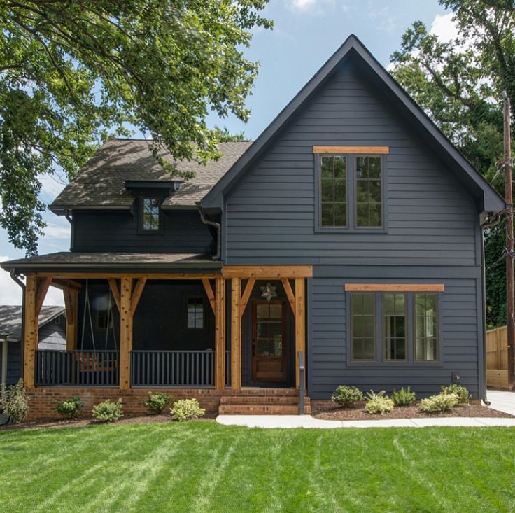 a large blue house sitting on top of a lush green field