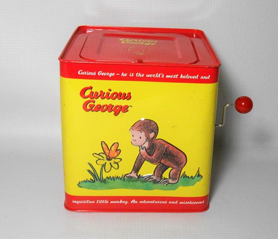 a yellow and red box with a monkey on it's side sitting next to a flower