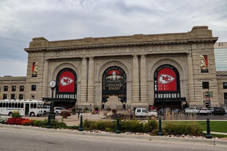 a large building with many windows on the front and side of it that has a lot of cars parked in front of it