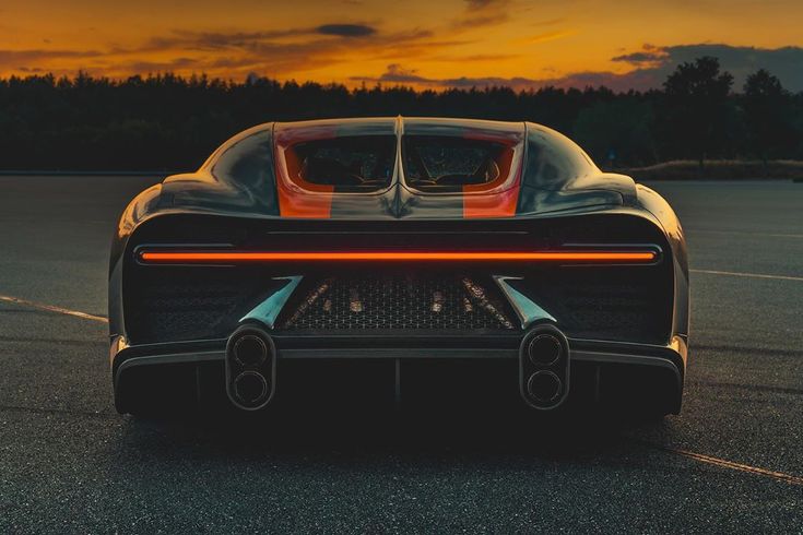 an orange and black sports car parked in a parking lot