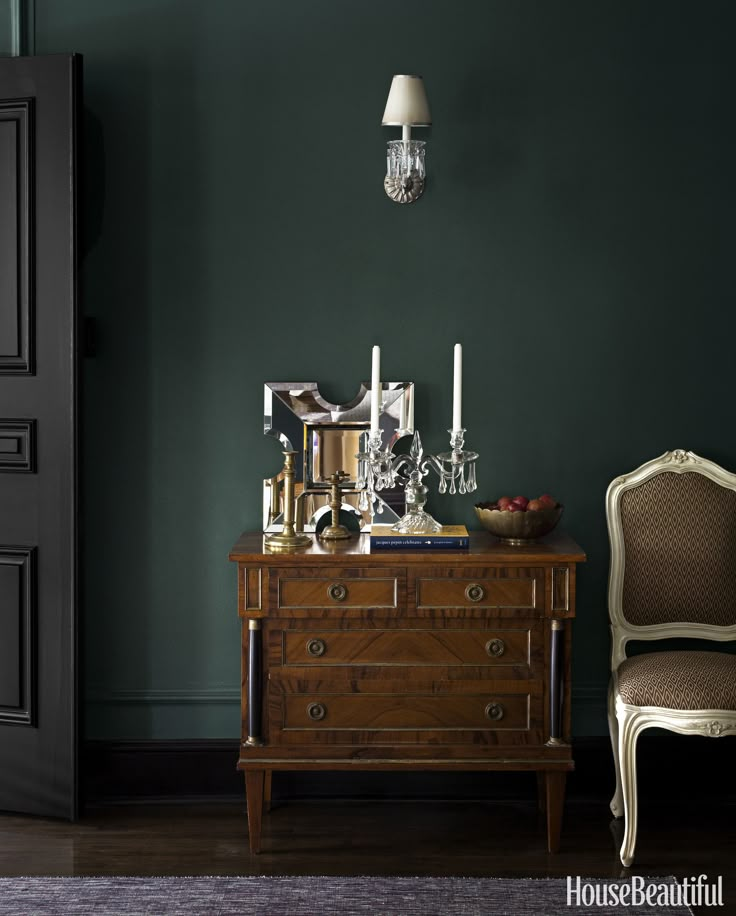 a room with green walls and an antique dresser