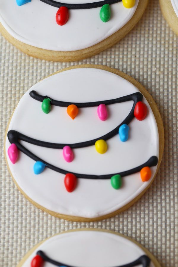 decorated cookies with colorful icing and lights on them sitting on top of a table