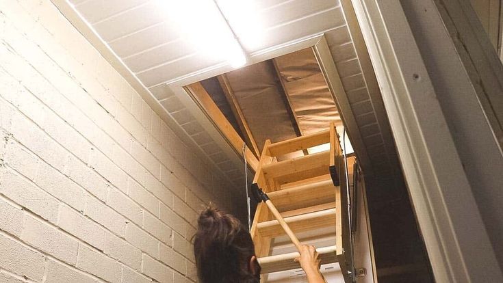 a woman standing in front of a ladder on the side of a building