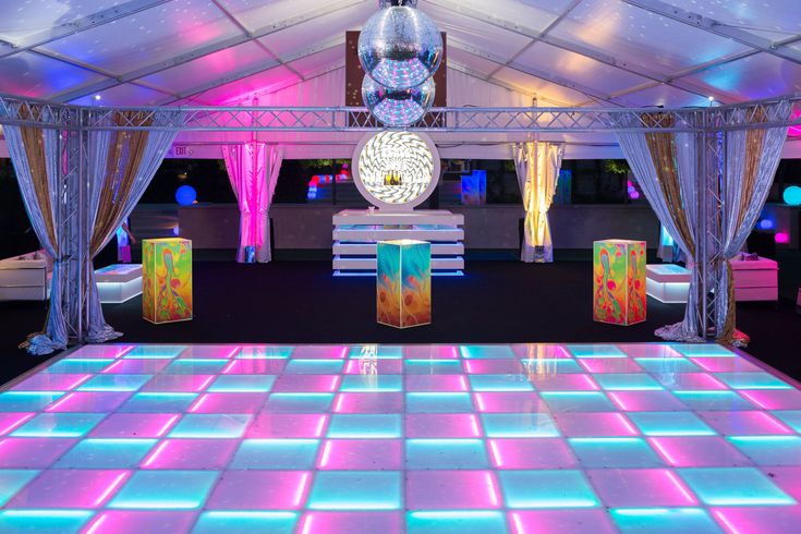 the dance floor is lit up with colorful lights