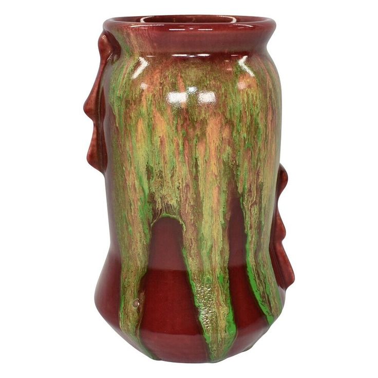 a red and green vase sitting on top of a table