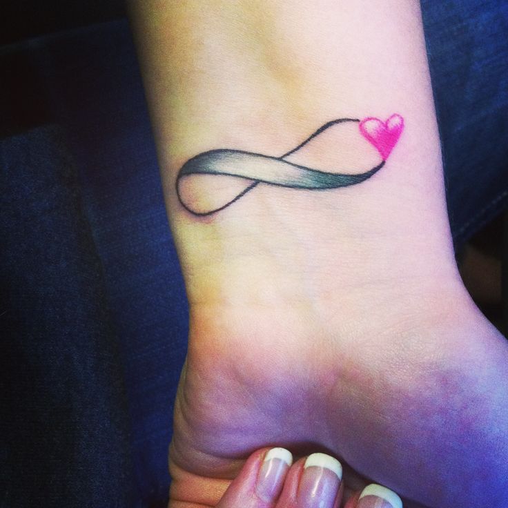 a woman's foot with a heart shaped tattoo on it