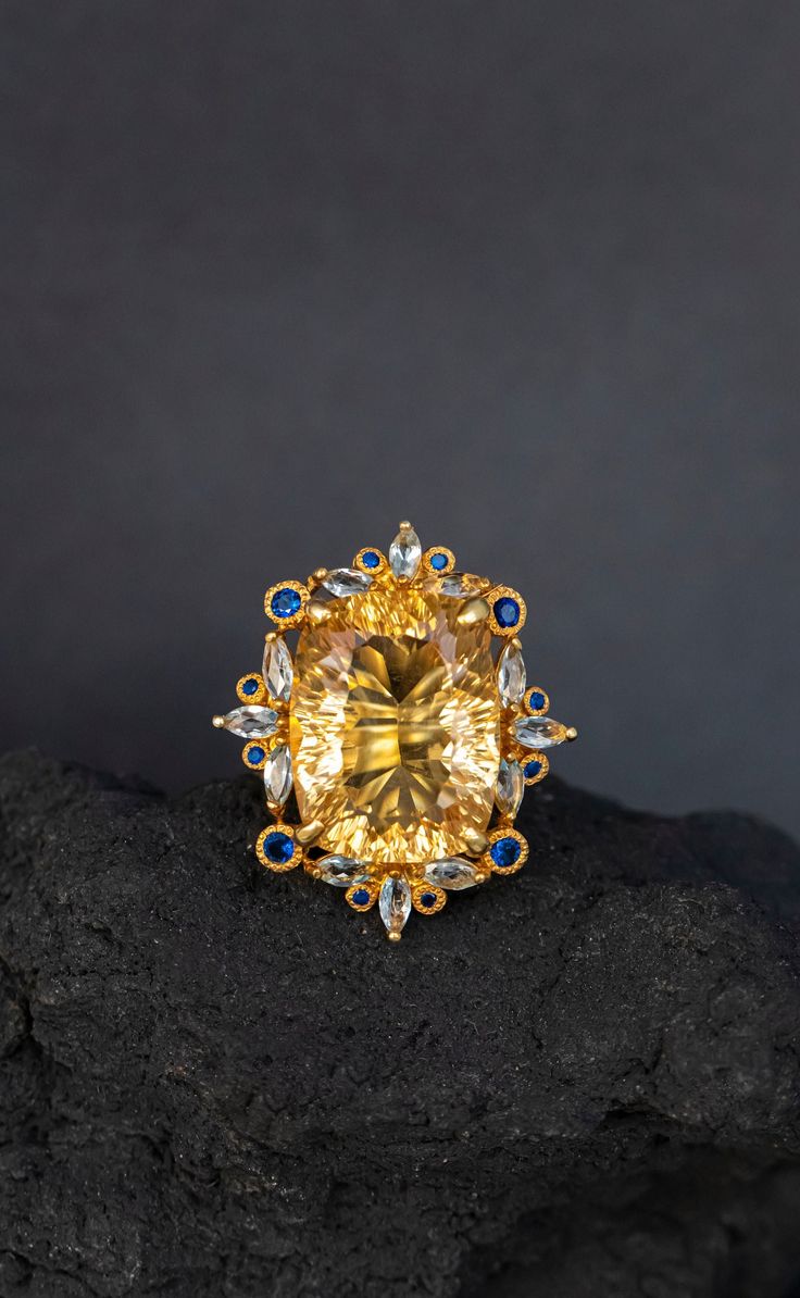 Statement ring with a huge natural yellow citrine framed in intricate lace of blue sapphire and topaz ! It's so stunning on a hand, you will fall in love with it :) ♥ The ring in the video is in size 6 US, the model has rather small hands :) ♥ The design can be made with gemstones of your choosing ♥ Each order will be gift wrapped beautifully ♥ QUALITY: Each item is stamped according to US regulations.  ------   *DIMENSIONS*  ------ ♥ Ring Size: All sizes will be made to order Main Metal: 925 St Elegant Yellow Oval Sapphire Ring, Elegant Oval Yellow Sapphire Ring, Elegant Yellow Sapphire Ring For Wedding, Formal Yellow Topaz Ring With Accent Stones, Elegant Yellow Sapphire Ring For Anniversary, Exquisite Sapphire Ring With Gemstone Accents, Yellow Sapphire Topaz Ring For Wedding, Elegant Yellow Sapphire Topaz Ring With Accent Stones, Elegant Yellow Sapphire Wedding Ring