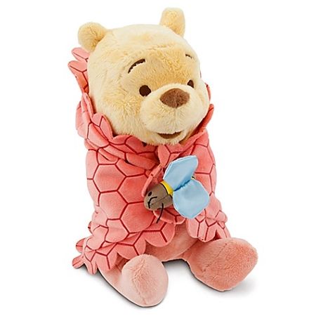 a winnie the pooh stuffed animal with a pink shirt and blue flower on it's chest