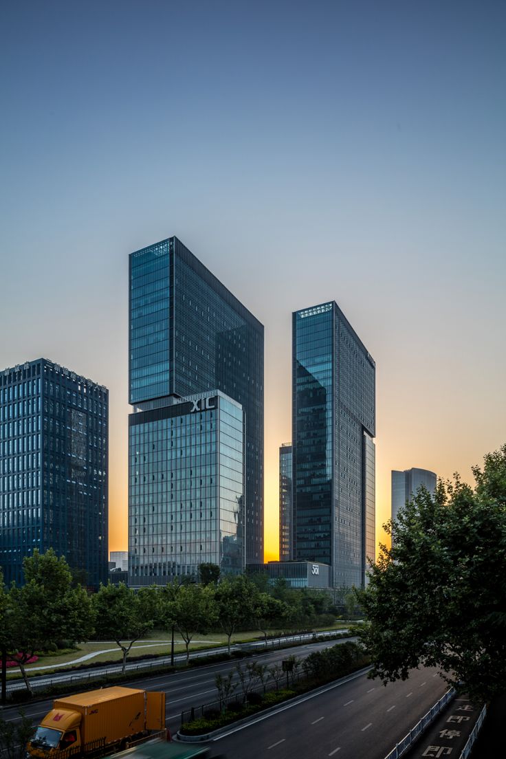 two large buildings are next to each other in the city at sunset or sunrise time