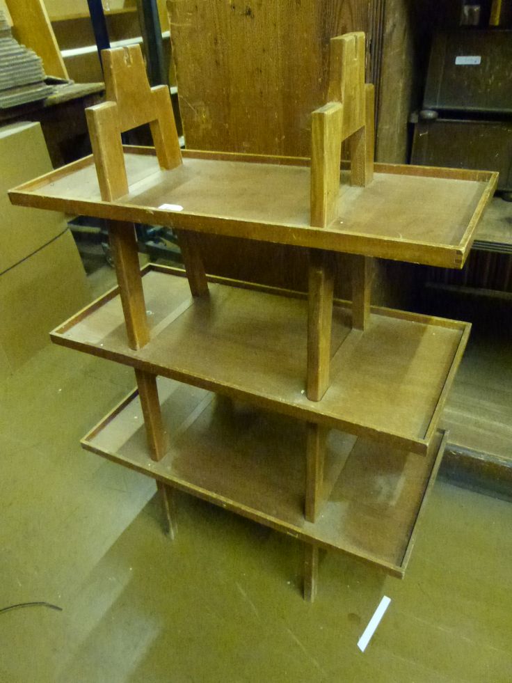 a wooden table sitting on top of a floor next to a pile of wood furniture