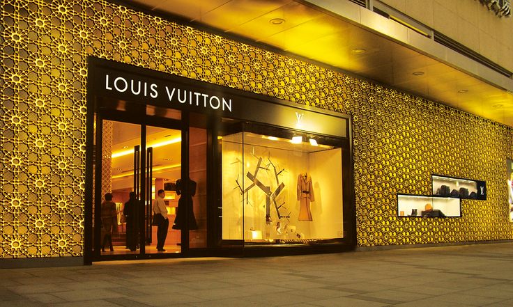 the storefront of louis vuitton is decorated with gold and black wallpaper