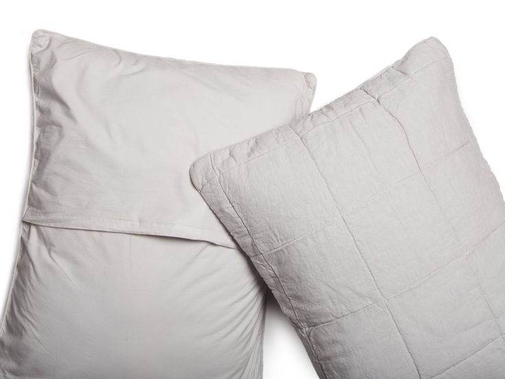 two pillows sitting next to each other on a white surface