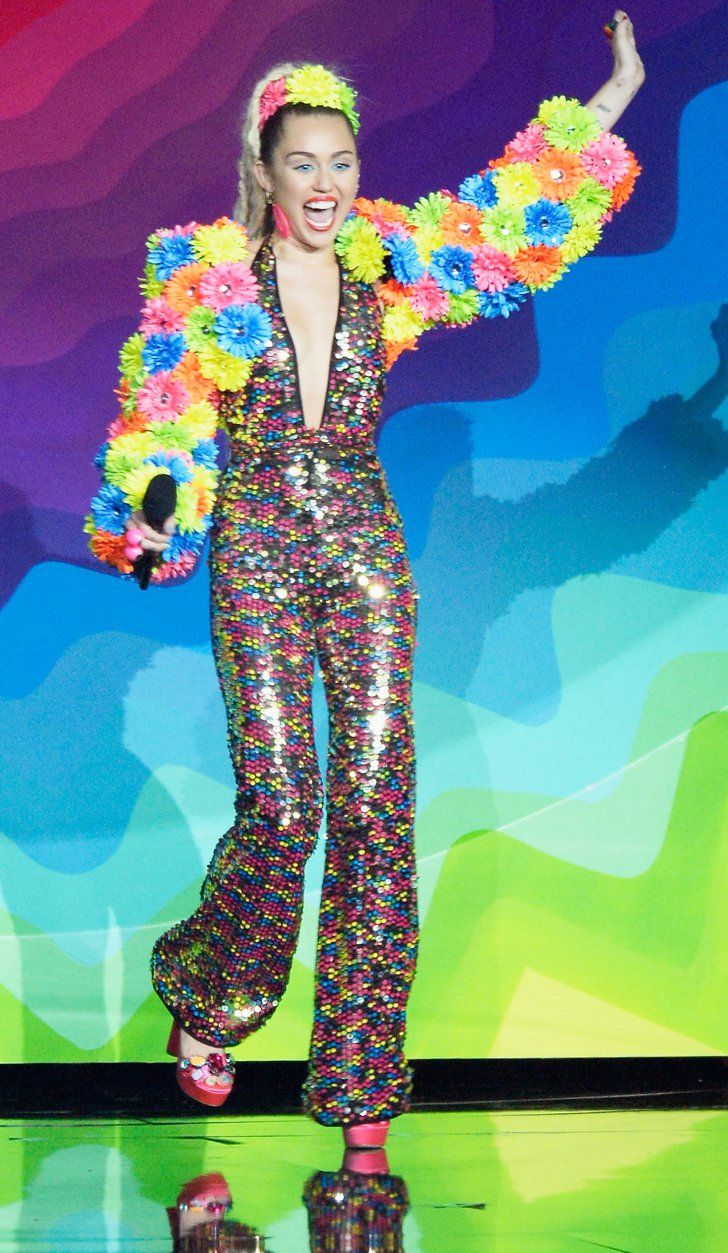 a woman in a colorful outfit on stage