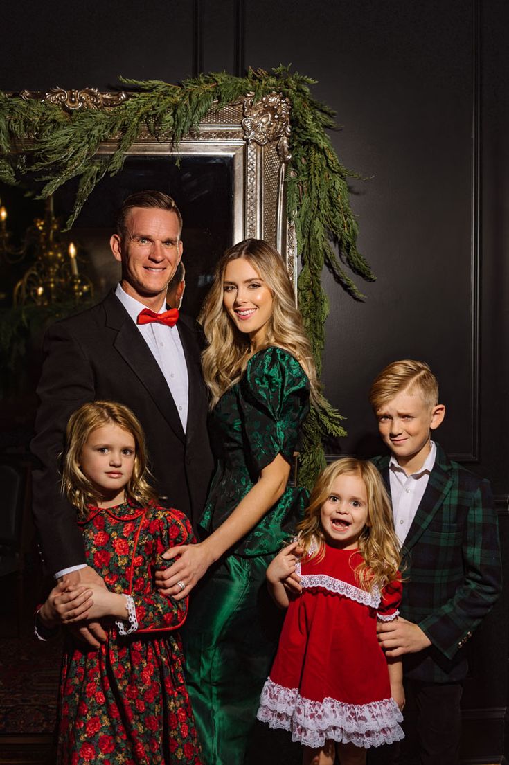 a man and two children standing next to each other in front of a christmas tree