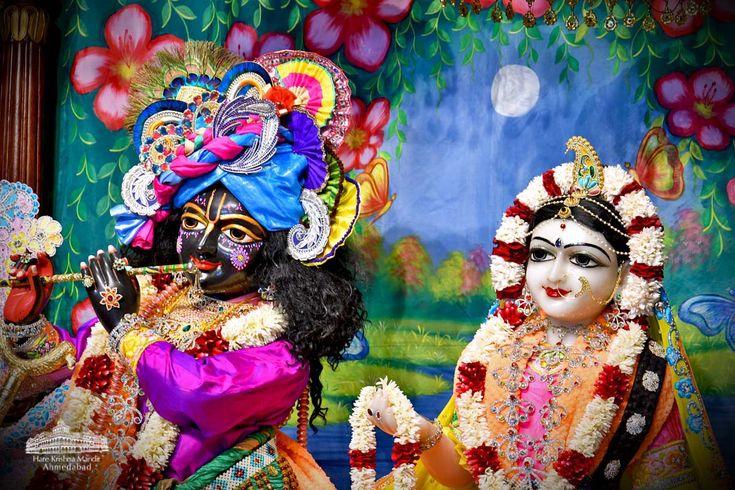 two people dressed in colorful costumes with flowers on them