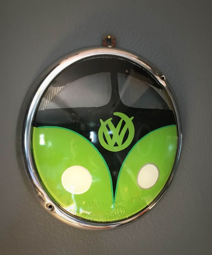 a green and black clock hanging on the side of a wall