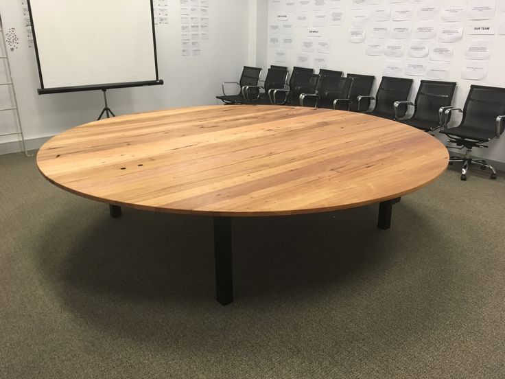 a round wooden table in an office setting