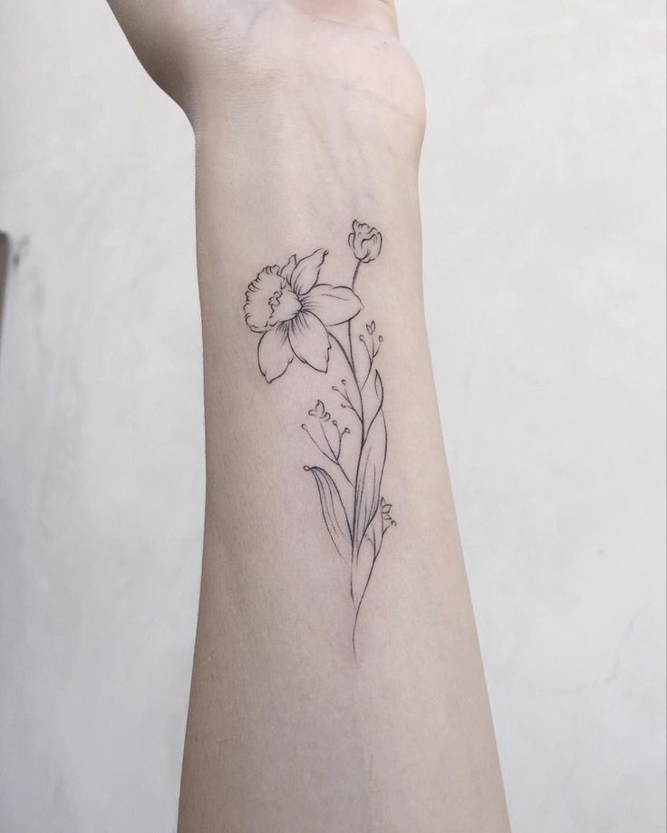 a woman's arm with a flower tattoo on it