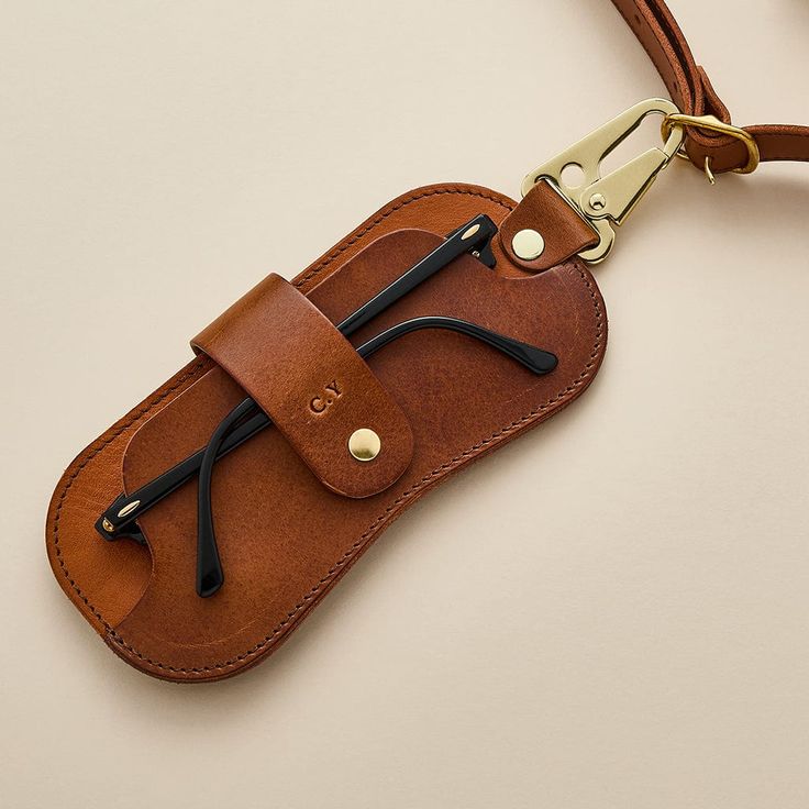 Handcrafted leather glasses case with side clip. Personalised with initials, available in black or brown. A beautifully crafted leather travel case for men’s glasses or sunshades in a clever minimalist design, with a handy trigger clip for attaching to your bag or belt. The smart, slim glasses cases have been designed with functionality in mind and have been thoroughly tested and refined to ensure the most practical finished product. The glasses cases are available in classic black or vintage tan brown leather and include complimentary personalised initials. We have developed two sizes to accommodate different sized frames, giving you the most suitable protection for your chosen pair. The smaller of the cases is great for slimmer reading specs, while the larger case suits retro-inspired su