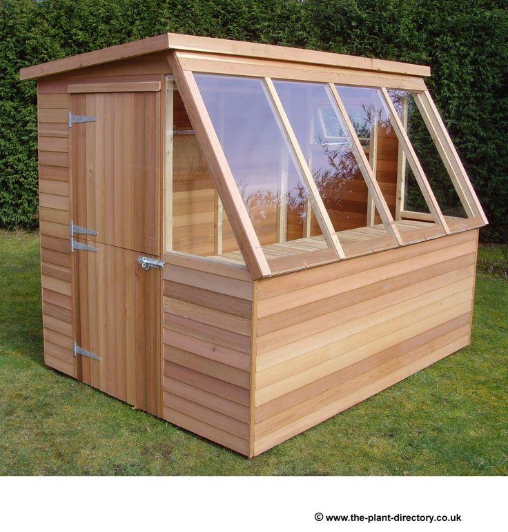 a small wooden shed with windows on the side