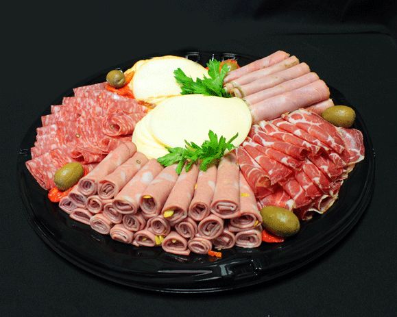 an assortment of meats and cheeses arranged on a black platter with green olives