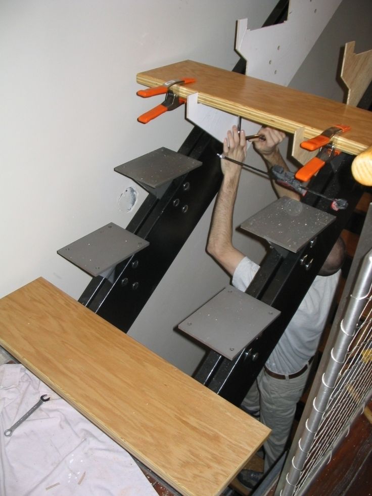 a man is working on an unfinished shelf