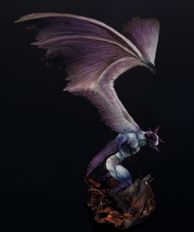 a figurine is shown in the dark with wings and claws on it's head