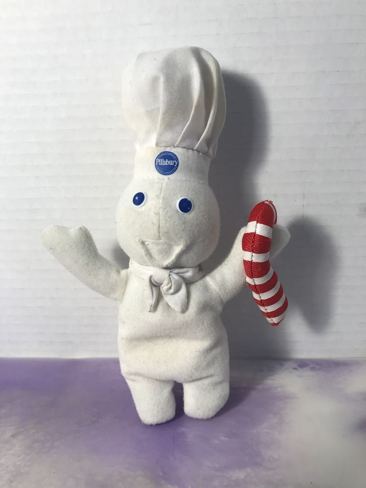 a stuffed animal with a chef hat holding a candy cane