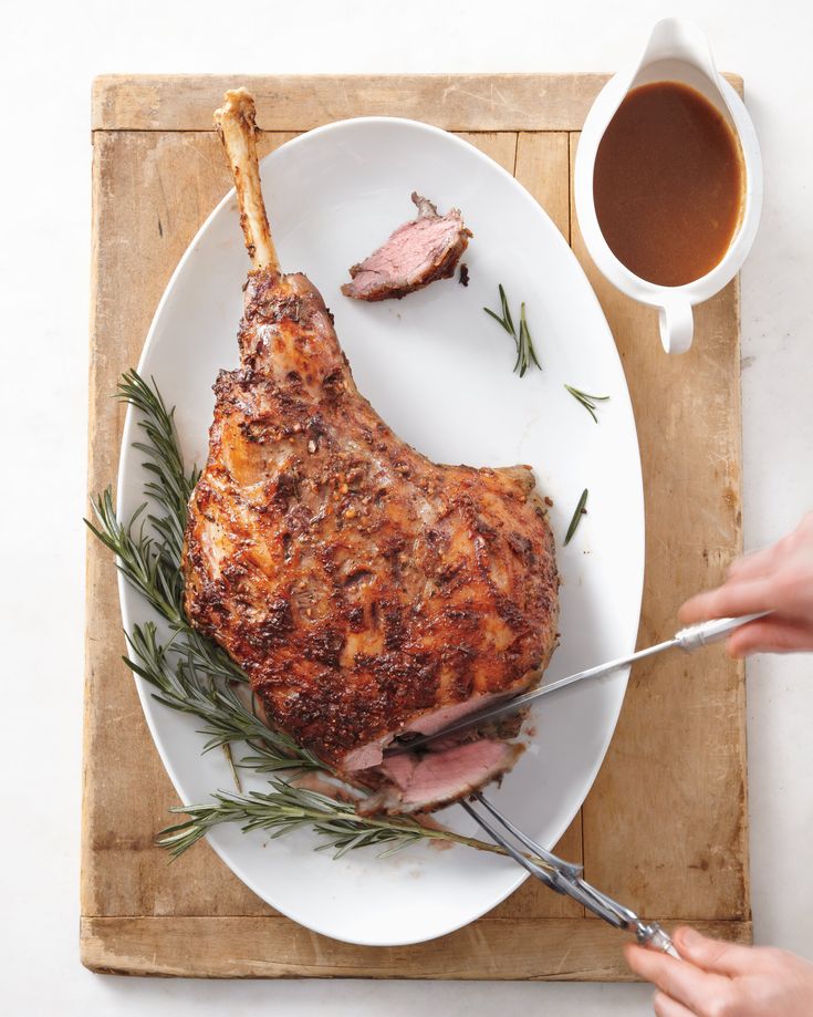 a person cutting up a piece of meat on a plate with a knife and fork