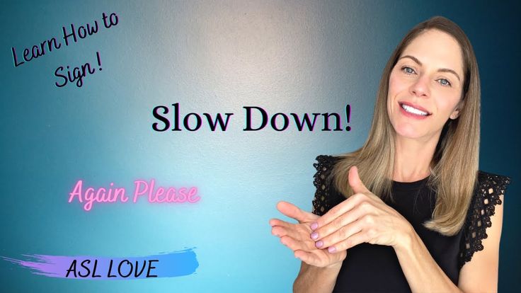 a woman standing in front of a blue wall with the words slow down