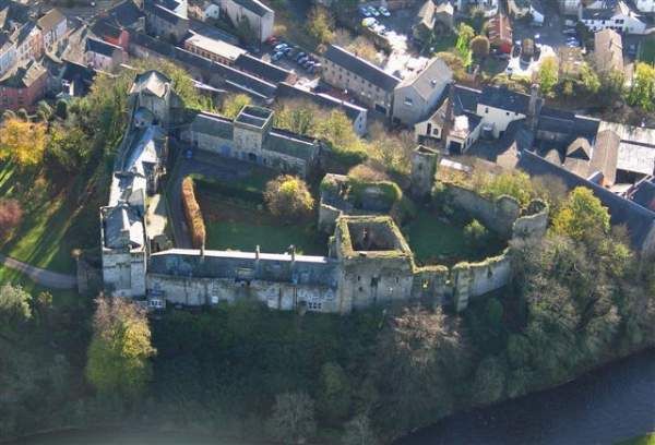 an aerial view of a castle in the middle of a town with lots of trees