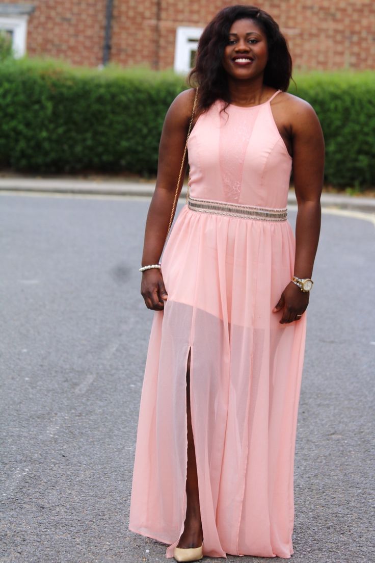 a woman in a pink dress standing on the street