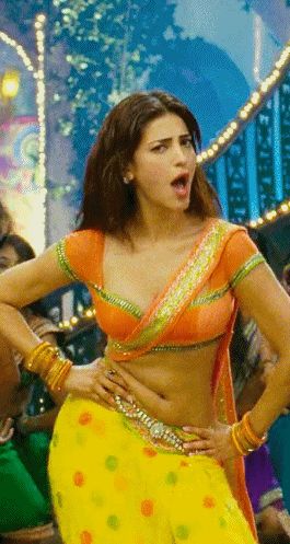 a woman in a yellow and orange outfit with her hands on her hips while dancing